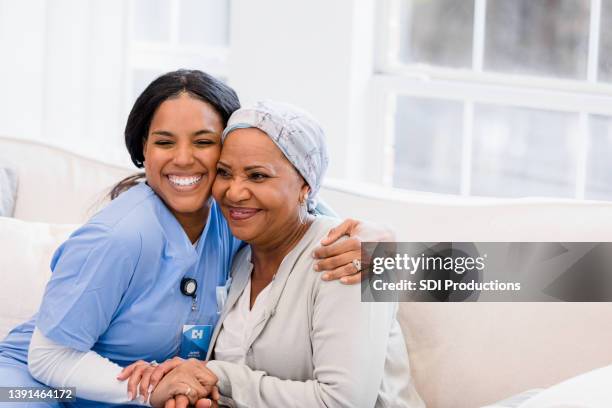 home healthcare nurse embraces her patient - hospitium stockfoto's en -beelden