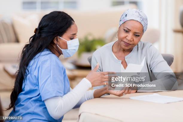 enfermeira do hospício fala com seu paciente com câncer - female surgeon mask - fotografias e filmes do acervo