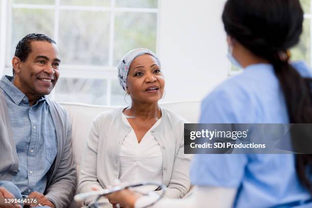 elderly couple sit with nurse to talk about lab results - married doctors stock pictures, royalty-free photos & images