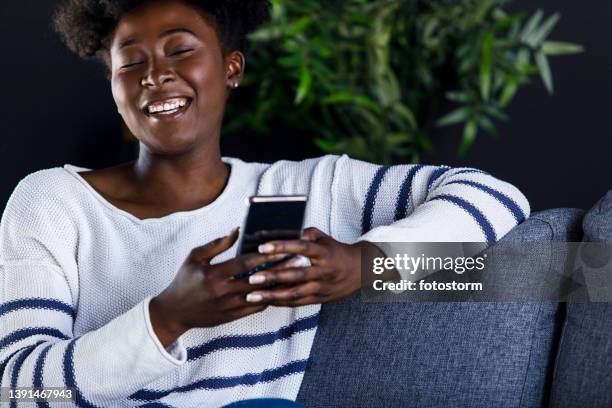 cheerful young woman laughing at funny memes she is scrolling through online - meme text stock pictures, royalty-free photos & images