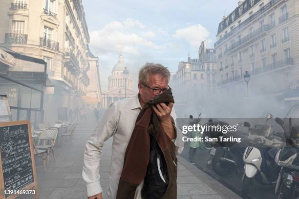 By-stander reacts to tear gas as students demonstrate in rejection of the two final candidates in the French presidential election - incumbent...