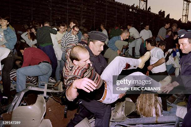 Picture taken on May 05, 1992 shows rescue workers attending to an injured man following the collapse of a stand at Furiani stadium causing 18 deaths...