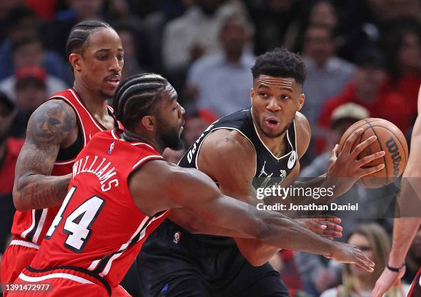 Giannis Antetokounmpo of the Milwaukee Bucks looks to pass under pressure from DeMar DeRozan and Patrick Williams of the Chicago Bulls at the United...