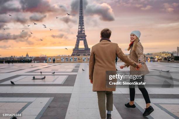 glückliches paar läuft in richtung eiffelturm bei parvis des droits de l'homme, paris - romantic sunset stock-fotos und bilder