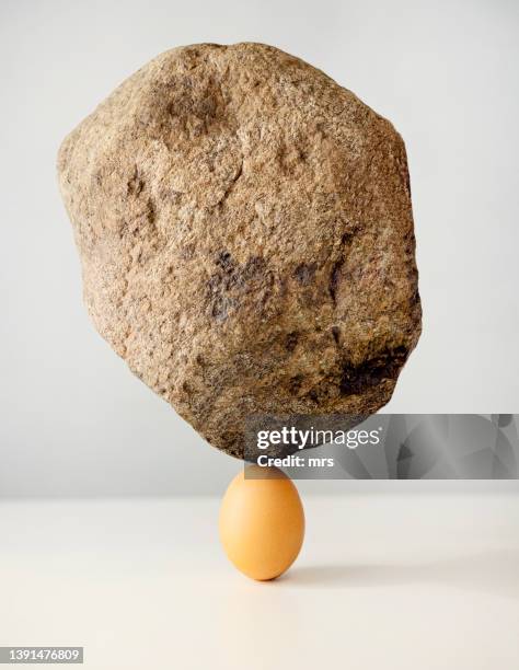 egg and large stone balance on it, strength concept - stone concept stockfoto's en -beelden
