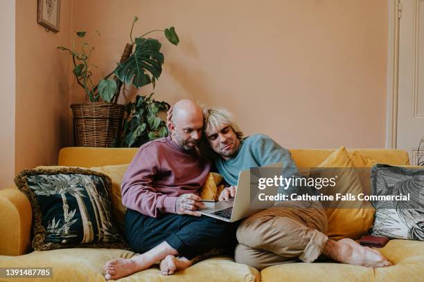 a happy couple shopping online with a laptop and a credit card. - electronic banking stock-fotos und bilder