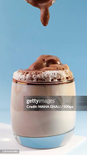 sprinkling cream on chocolate against blue background - café frappé fotografías e imágenes de stock