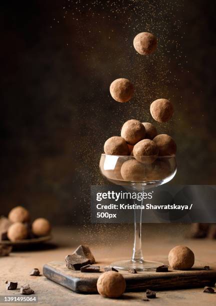 chocolate truffles dropping in a glass against brown background,belarus - chocolate truffle stock pictures, royalty-free photos & images