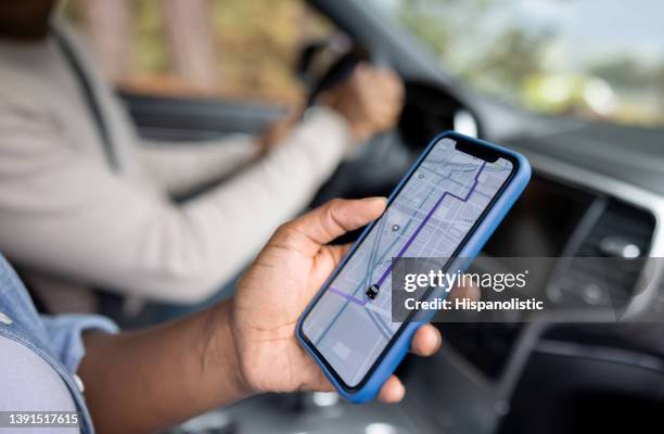 close-up em um casal usando o gps enquanto dirige um carro - aplicação móvel - fotografias e filmes do acervo