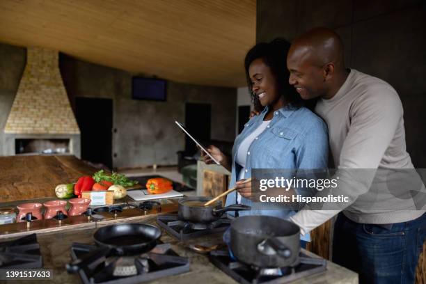 happy couple cooking at home following an online recipe - dinner program stock pictures, royalty-free photos & images