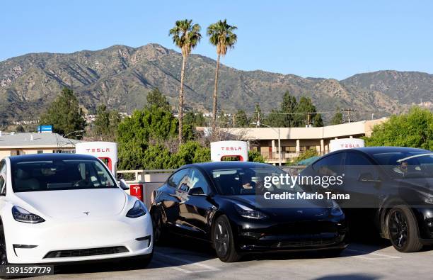 Tesla cars recharge at a Tesla Supercharger station on April 14, 2022 in Burbank, California. California has unveiled a proposal which would end the...