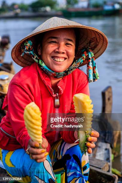 mujer vietnamita vendiendo piñas en el mercado flotante, delta del río mekong, vietnam - mekong fotografías e imágenes de stock