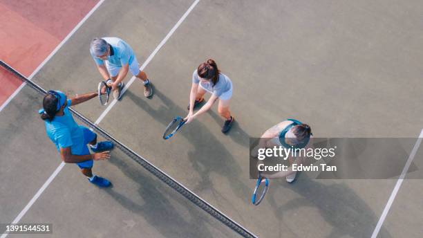 point de vue drone instructeur de tennis asiatique guidant ses étudiants adultes servant le ballon - tennis coaching photos et images de collection