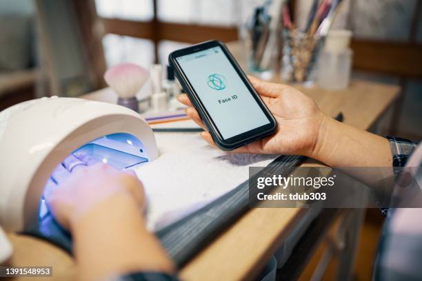 mid adult woman using facial identification technology to log in to her cryptocurrency wallet on a smart phone - facial recognition technology stock pictures, royalty-free photos & images