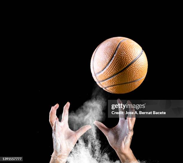 hands of a basketball player catching a ball on a black background. - ballon rebond stock pictures, royalty-free photos & images