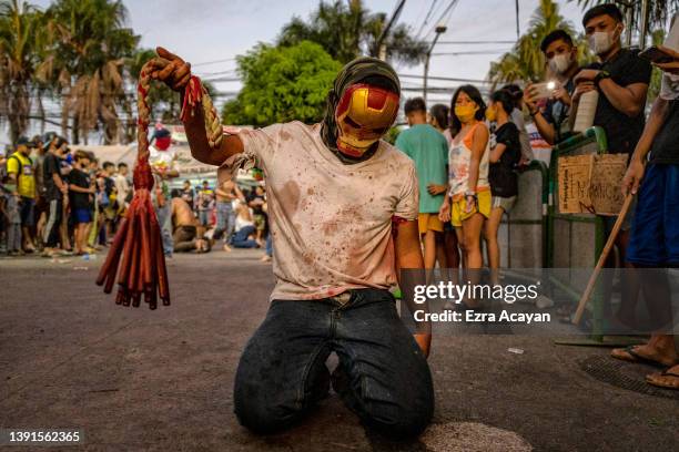 Flagellant with a bloodied back flogs himself as he performs Good Friday Lenten Rites on April 15, 2022 in Navotas, Metro Manila, Philippines....