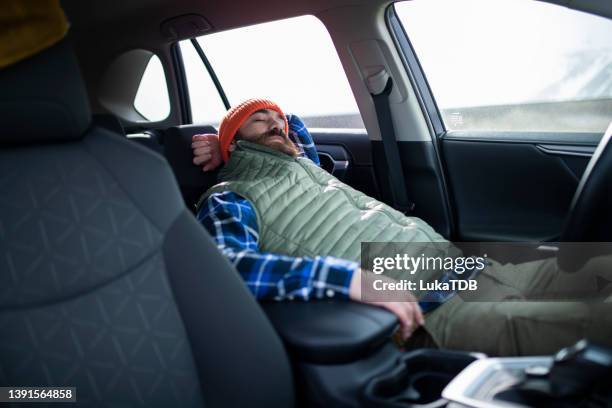 during a strenuous car journey, the bearded man took a break. isl - sleeping in car stockfoto's en -beelden