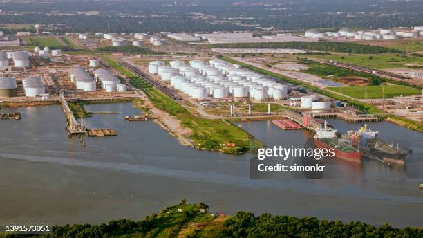 oil refinery along river - tank barge stock pictures, royalty-free photos & images