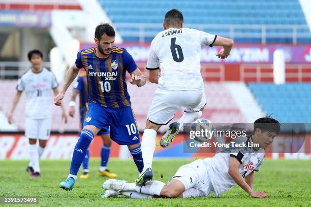 Valeri Qazaishvili of Ulsan Hyundai competes for the ball against Joao Schmidt Urbano and Miki Yamane of Kawasaki Frontale during the first half of...