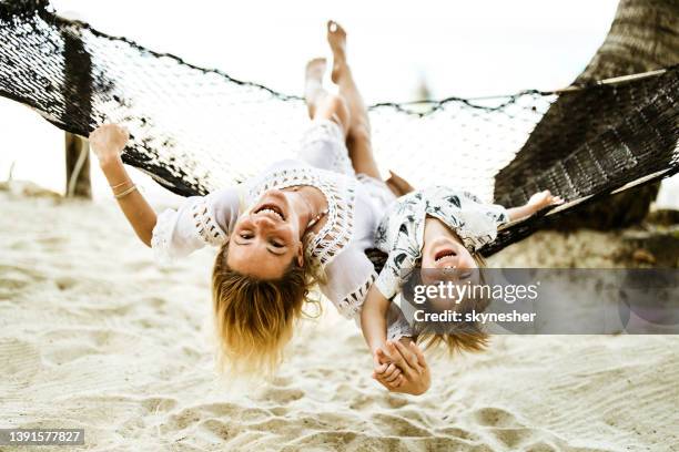 carefree single mother and son having fun in hammock on the beach. - hammock asia stock pictures, royalty-free photos & images