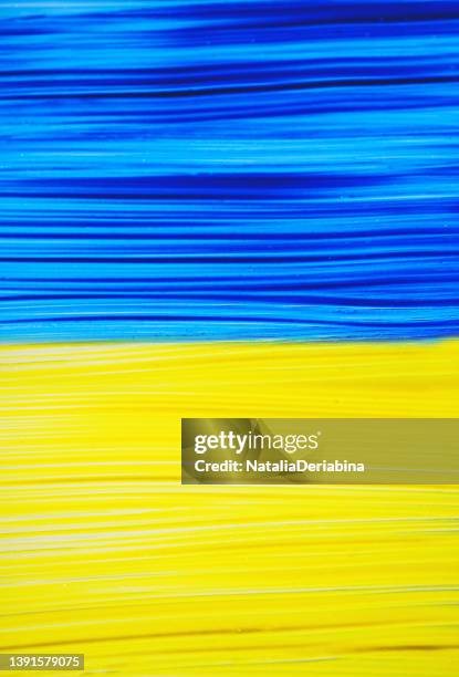 Photo of painting Ukraine flag on window. Ukraine flag brush concept. Color image of flag of Ukraine on glass with paints. Banner with symbol, background.