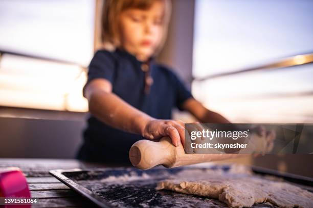 バルコニーの生地にローリングピンを使用して小さな男の子のクローズアップ。 - 麺棒 ストックフォトと画像