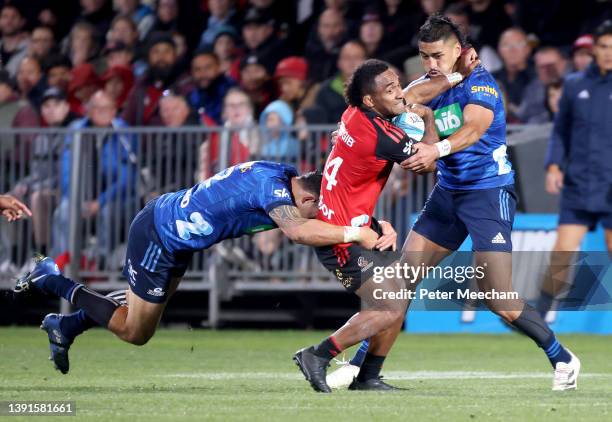Sevu Reece from The Crusaders is tackled by Bryce Heem, left, and Reiko Ioane from the Blues during the round four Super Rugby Pacific match between...
