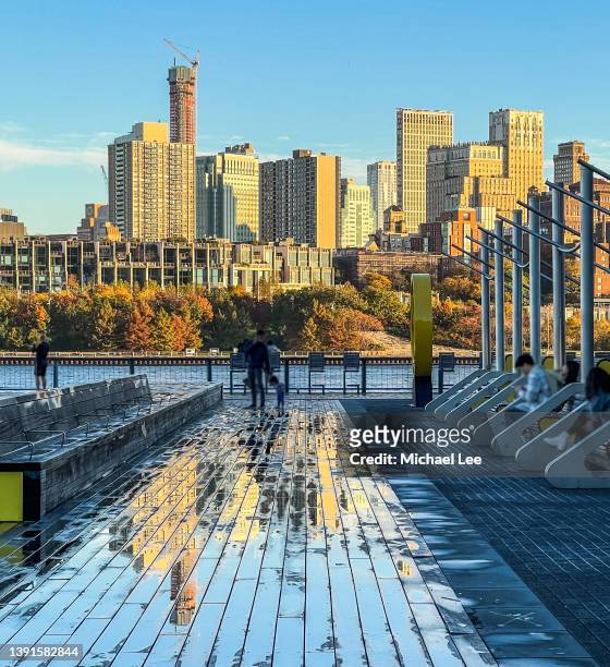 autumnal brooklyn skyline view reflected on wet boardwalk in new york - brooklyn heights stock pictures, royalty-free photos & images