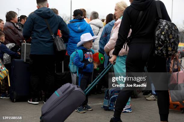 Martin Kananirov and his mother Inna Kananirova wait for a bus that will take them to Poland from the main train station on April 15, 2022 in Lviv,...