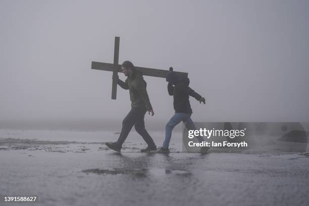 Pilgrims celebrate Easter by carrying wooden crosses as they walk over the tidal causeway to Lindisfarne during the final leg of their annual Good...