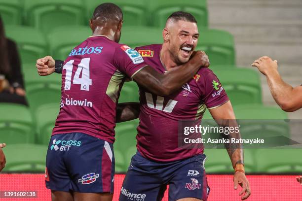 Connor Vest celebrates with Suliasi Vunivalu of the Reds after scoring a try during the round nine Super Rugby Pacific match between the Melbourne...