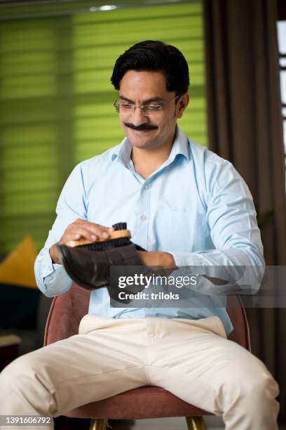 happy man polishing his shoes and getting ready for office - career ready stock pictures, royalty-free photos & images