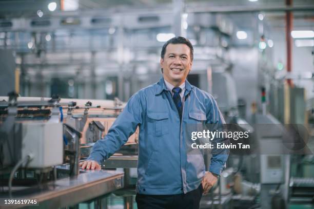 direttore di fabbrica dell'uomo maturo malese asiatico che guarda sorridente della fotocamera - industrial laborer foto e immagini stock