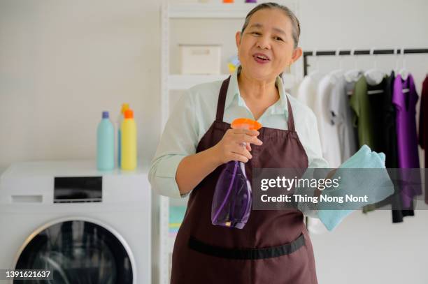 happy smiling asian senior elderly female woman  cleaning and housekeeping, looking at camera - cleaner man uniform stock-fotos und bilder