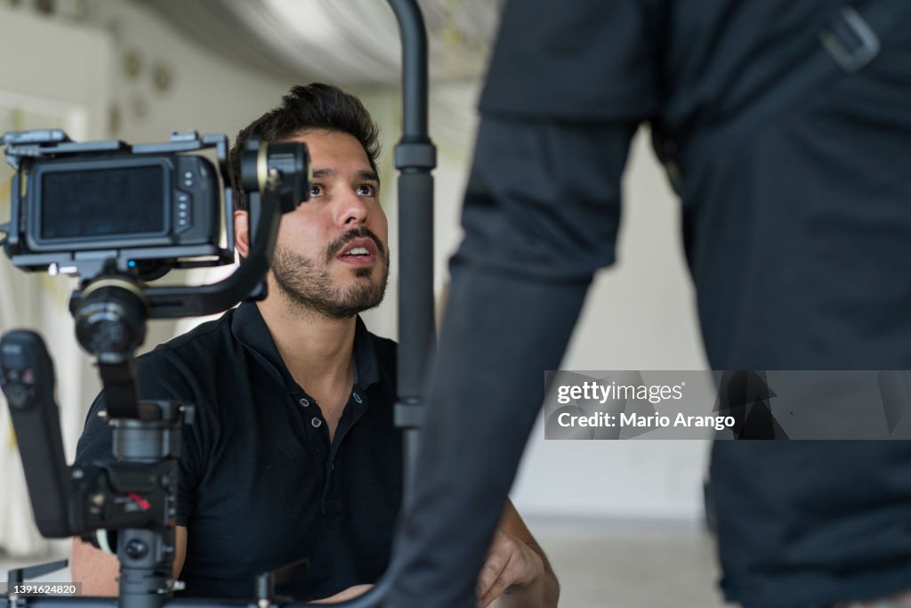 Video camera in film or movie production on tripod and professional gear which shooting in location or studio with crew team and beautiful prop or set and ready to online live broadcast or tv on air later