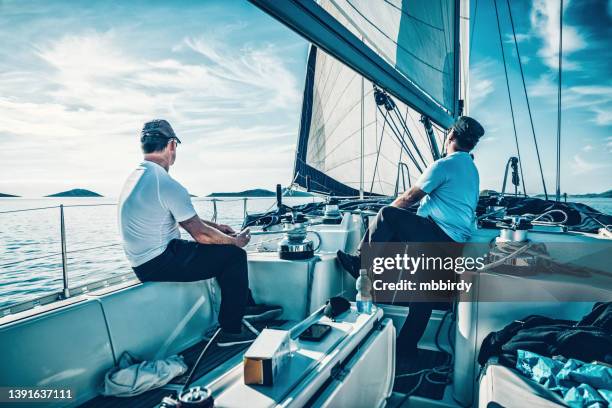 sailors winding rope on winch and pulling it - yachting stock pictures, royalty-free photos & images