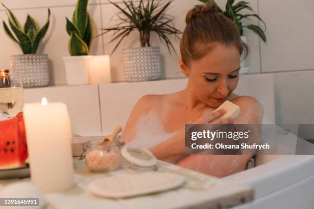 woman in bath with aroma soap - bath salt stock-fotos und bilder