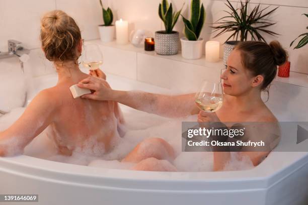 two woman take a bath with foam - woman bath bubbles stock-fotos und bilder