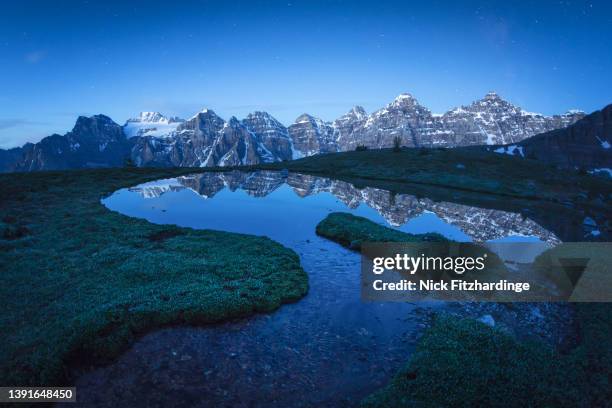 the ten peaks reflected in a small lake in larch valley at blue hour in the canadian rockies - hora azul crepúsculo fotografías e imágenes de stock