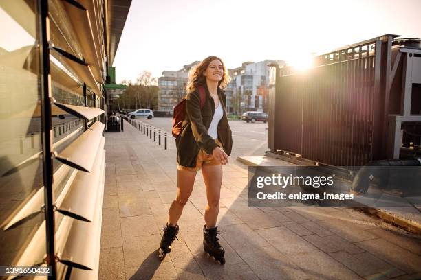 young woman on inline roller skates - rolschaatsen schaats stockfoto's en -beelden