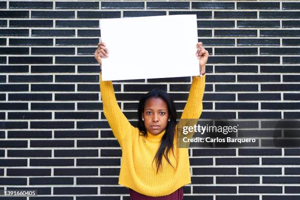 serious portrait of woman showing an empty placard. - activists hold vigil marking 50th anniversary of march on the pentagon stockfoto's en -beelden