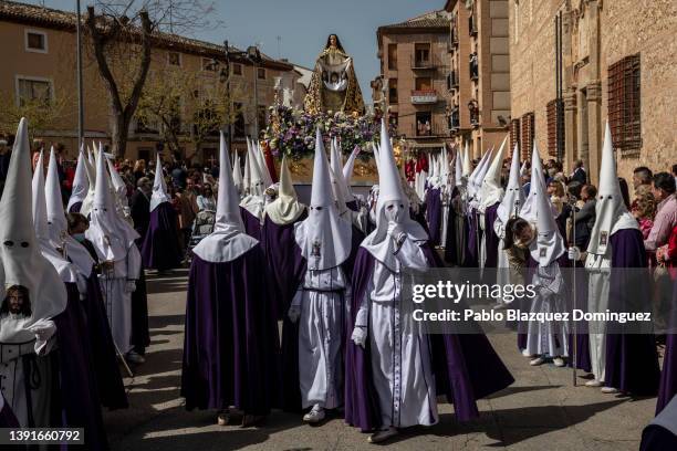 Penitents from the 'Santa Mujer Veronica' brotherhood carry their image during 'Las Caidas' procession on Good Friday on April 15, 2022 in Ocana,...