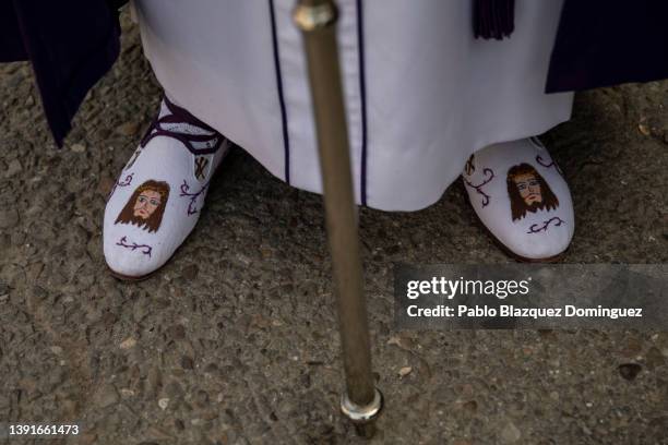 Penitent from the 'Santa Mujer Veronica' brotherhood wears an image of Jesus Christ on his shoes during 'Las Caidas' procession on Good Friday on...