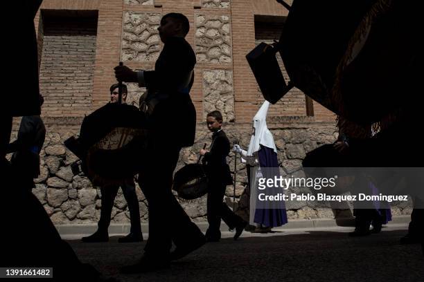 Musicians play drums next to a penitent from the 'Santa Mujer Veronica' brotherhood during 'Las Caidas' procession on Good Friday on April 15, 2022...