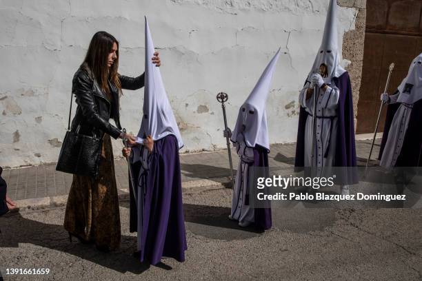 Woman adjust the hood to young penitent from the 'Santa Mujer Veronica' brotherhood during 'Las Caidas' procession on Good Friday on April 15, 2022...