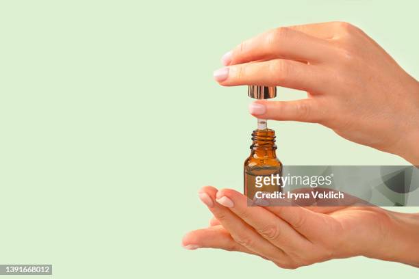 woman hands hold natural beauty product facial serum or essential oil . - enzymes cosmetics foto e immagini stock