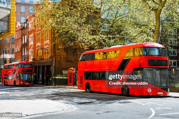 stationary red buses on street of london - london bus stockfoto's en -beelden