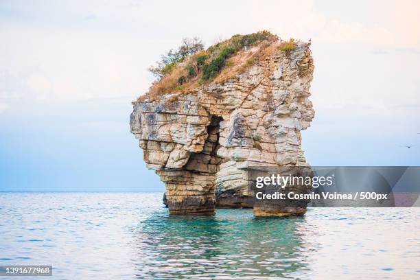 picturesque islets faraglioni di puglia in bay baia delle zagare - baia foto e immagini stock