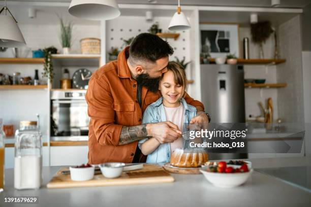 niña haciendo y decorando pasteles con su padre - decorating a cake fotografías e imágenes de stock