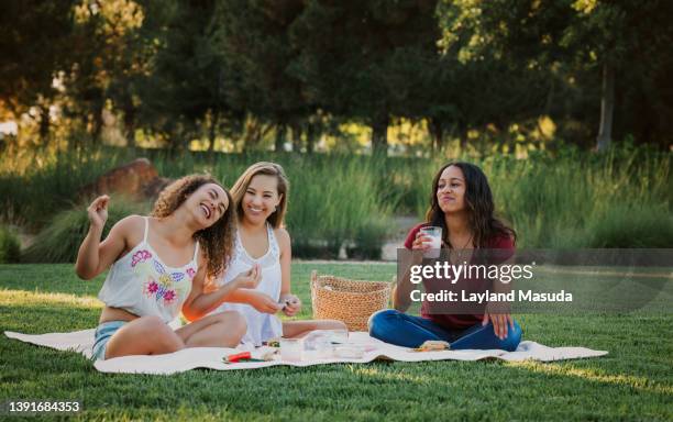 teen girl picnic - girls laughing eating sandwich stock-fotos und bilder